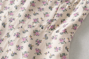 Détail du tissu en mousseline florale avec fleurs violettes et coutures à volants