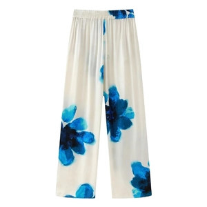 Detail of high-waist elastic waistband on fluid cream trousers with blue floral print