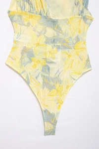 Detail view of tropical floral mesh bodysuit with asymmetrical draped tulle and deep V-neck