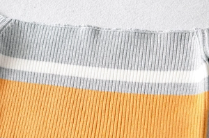 Detailed macro view of the striped ribbed knit fabric with precise overlock stitching