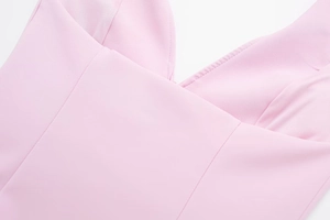 Detailed view of the pink V-neck halter top featuring pleated bust and smooth fabric texture