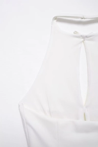 Detail eines weißen Neckholder-Tops mit kleiner Schleife und Tropfen-Ausschnitt Design