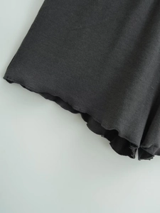 Detail of dark grey ribbed knit fabric with lettuce hem edge on loose shorts