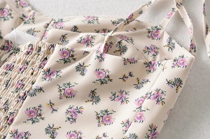 Détail de robe d'été à fleurs mauves avec conception à smocks élastiques sur le tissu