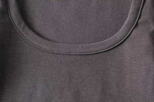Detail of high-density dark grey knit fabric and ribbed crew neck stitching on a crop top
