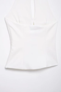 Nahaufnahme des weißen Halterneck-Tops mit Cut-out vorne und glatter Webstoffstruktur