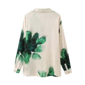 Detail of floral printed long sleeve shirt with classic lapel and green leaf pattern
