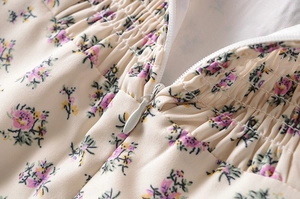 Détail de la fermeture éclair invisible et du tissu smocké sur la robe à fleurs