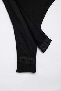 Macro view of snap button closure and elastic mesh fabric texture on black bodysuit