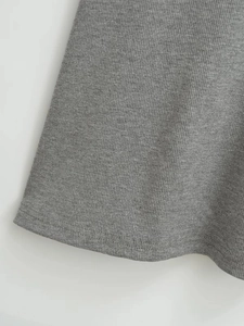 Gros plan sur la texture en maille côtelée grise et la couture à double aiguille du bas