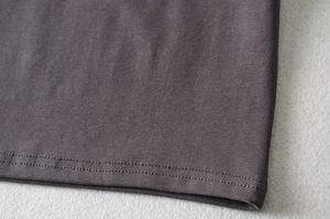 Detailed close-up of the double-needle hem and ribbed knit texture on the crop top