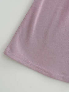Détail de l'ourlet de la robe en tricot lavande avec texture côtelée et double couture