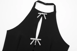 Detail eines schwarzen Neckholder-Tops mit Keyhole-Ausschnitt und Glitzer-Schleifen