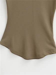 Detail of tan ribbed knit shirt featuring a curved scalloped hem and double stitching