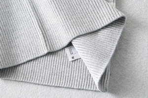 Detail shot of the ribbed knit fabric texture and care label on this grey crop top