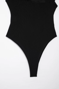 Close-up of black ribbed bodysuit featuring sheer mesh panels and high-cut leg design