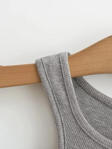 Close-up of gray ribbed knit crop top featuring detailed stitching and fabric texture