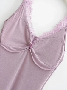 Détail de la robe en tricot lavande avec dentelle de cils et nœud en velours au décolleté
