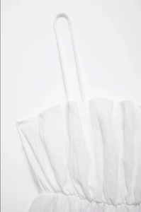 Close-up of white textured summer top with pleated chest detail and thin straps