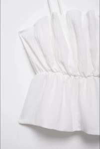 Close-up of white summer camisole featuring vertical pleated texture and slim straps