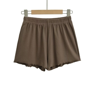 Detailed view of dark brown ribbed knit shorts with elastic waist and wavy lettuce hemline