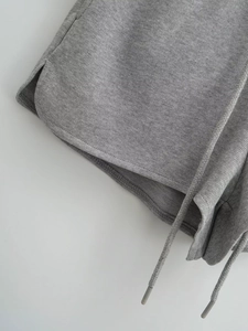 Détail du short en maille gris chiné avec fentes latérales et cordon de serrage