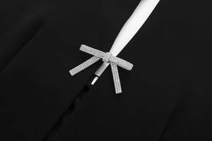 Detailansicht aus schwarzem Webstoff mit glitzernder Strass-Schleife und weißem Innenfutter