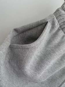 Vue détaillée de la taille élastique et de la poche latérale du short en maille gris