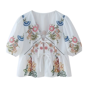 White V-neck top with colorful floral embroidery and front ties in a summer boho style