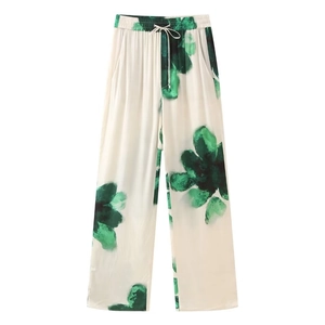 Detail view of floral print wide-leg trousers with elastic drawstring waist and side pockets