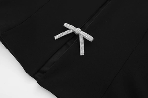Nahaufnahme der eleganten Strass-Schleife auf dem schwarzen Halterneck-Top