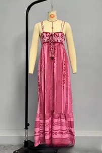 Detail of bohemian pink maxi dress showing crochet embroidery and tassel neck tie
