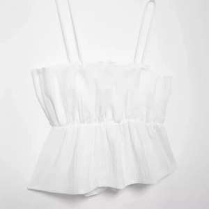 White ruffled summer camisole with pleated bust and flared hem for a slim fit look
