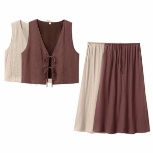 Detailed view of the bow-tie vest and maxi skirt set with pleated fabric texture