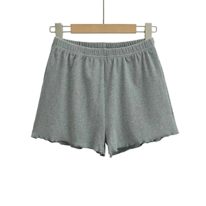 Detail of grey ribbed women's shorts showing elastic waistband and wavy hemline textures