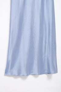 Detailed macro view showing the silky light blue satin fabric and hemline of the dress