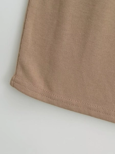 Dettaglio dell'abito in maglia a coste kaki con finitura dell'orlo a doppia cucitura