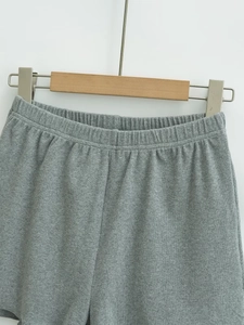 Detail of grey ribbed knit shorts featuring an elastic waistband and soft textured fabric