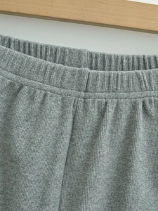 Detail of grey ribbed knit fabric showing elastic waistband and vertical striped texture