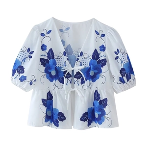 Women's white V-neck short sleeve top with blue floral print and peplum waist detail