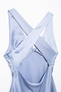Detail of light blue satin midi dress showing cross back straps and hidden side zipper