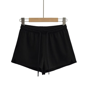 Détail du short noir en maille côtelée avec taille élastique à cordon et fentes latérales