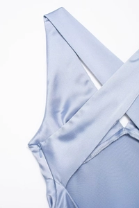 Detail of light blue satin midi dress showing crossover straps and invisible zipper