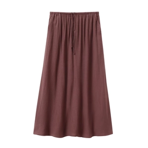 Detail of chocolate brown maxi skirt with elastic drawstring waist and pleated texture