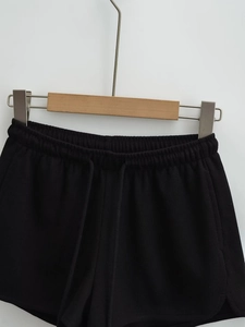 Détail du short noir côtelé avec taille élastique à cordon et fentes sur les côtés