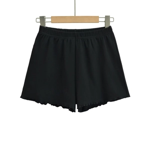 Detailed view of black ribbed knit shorts with elastic high waist and ruffle hem details