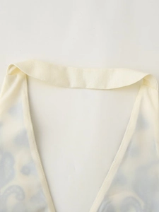 Dettaglio dello scollo all'americana con stampa paisley blu su tessuto beige chiaro