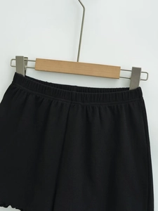 Close-up of black ribbed knit fabric and elastic waistband on casual high waist shorts
