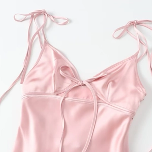 Pink satin dress with adjustable tie-straps and elegant bow detail on the V-neckline