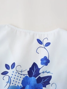 Close-up of neckline with blue and white floral print on woven fabric blouse